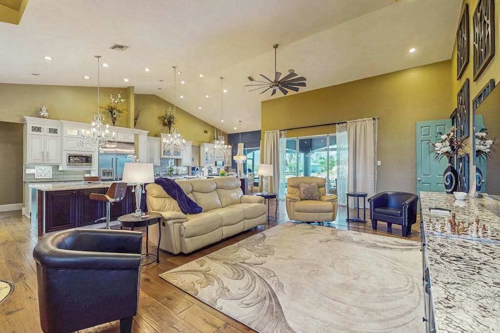 A spacious living area with a large rug, a sofa, a coffee table, and a dining area with a marble countertop.