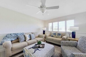 A living room with two sofas, a coffee table, a ceiling fan, and a window with blinds. - Dog-friendly home with screened lanai, central AC, & washer/dryer (Cape Coral)