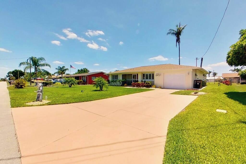 A residential area with a house, a lawn, and a clear sky.