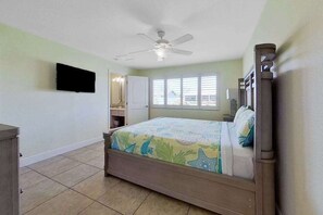 A bedroom with a bed, a ceiling fan, a window, and a TV mounted on the wall. - Dog-friendly home with screened lanai, central AC, & washer/dryer (Cape Coral)