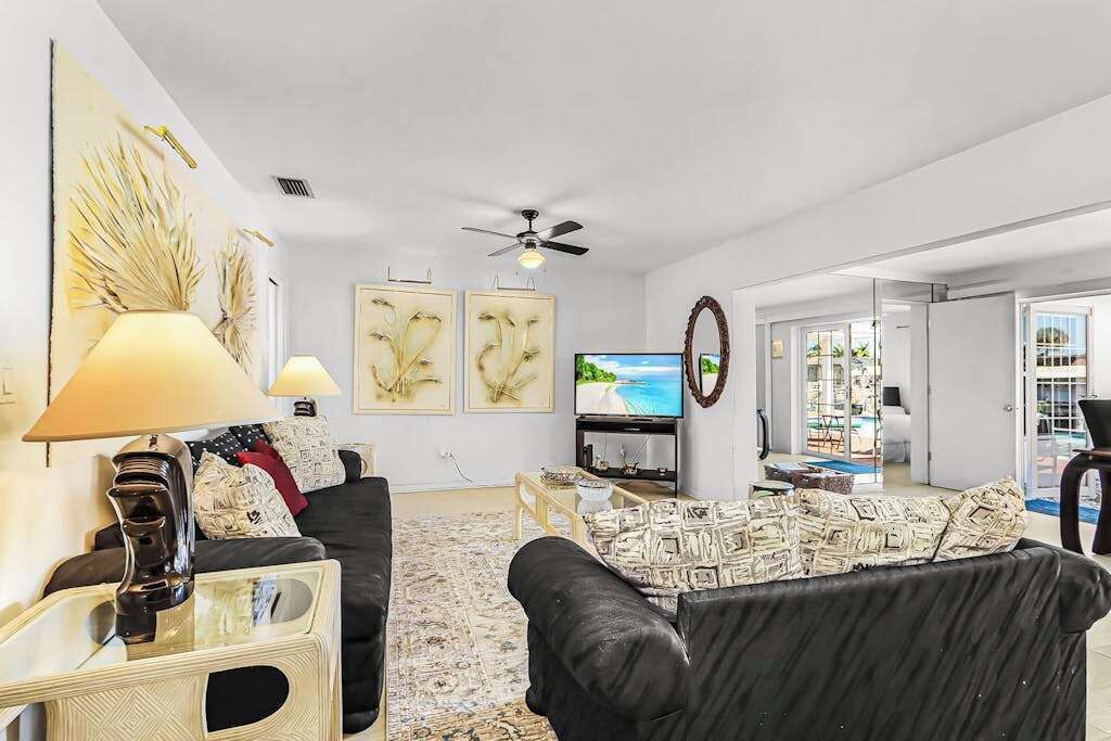 A living room with a sofa, a TV, and artwork on the wall.