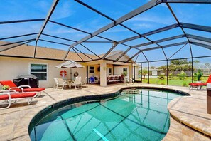 Ein Swimmingpool mit Glasveranda, Sitzgelegenheiten im Freien und Blick auf die umliegende Landschaft.