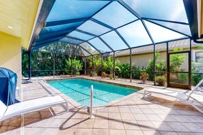 An indoor swimming pool with a glass ceiling, tiled floor, and lounge chairs. - Newly designed home w/private heated pool, deck, AC heat recovery system (Naples)