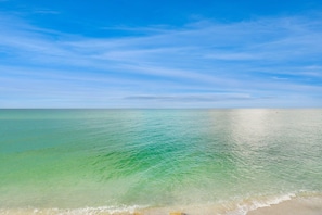 Une plage avec une eau cristalline et un ciel dégagé.