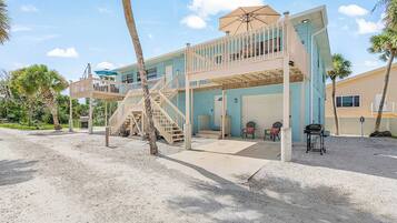 A two-story building with a balcony, a staircase, and a covered outdoor seating area.