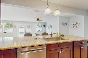 A kitchen with granite countertops, stainless steel appliances, and pendant lighting. - Coastal home with private pool, arcade games, and firepit (Fort Myers)