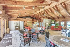 A spacious lobby with high ceilings, wicker furniture, and a stone accent wall. - Ideal Naples Getaway W/ Shared Pool, Tennis Courts, & Central AC (Naples)