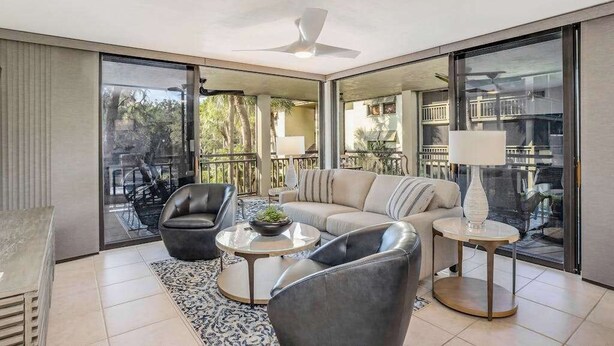 A modern living room with a sofa, two armchairs, a coffee table, and a lamp. - 2nd-floor condo with private beach access, lanai, and access to heated pool (Bonita Springs)