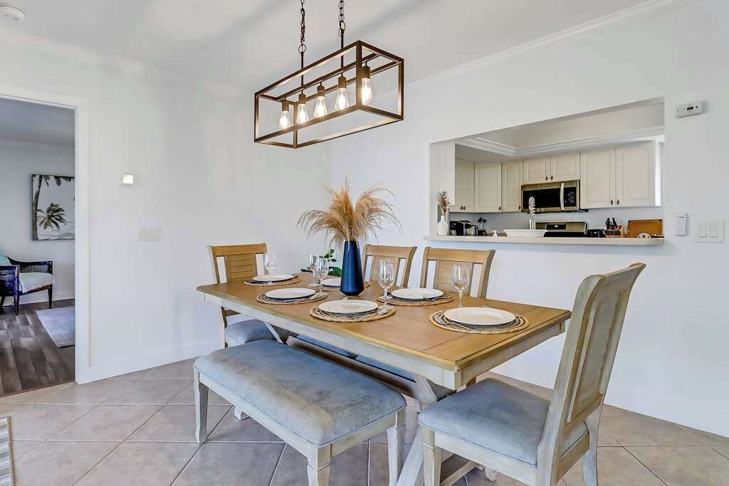 Un comedor con mesa de madera, sillas y una lámpara colgante.