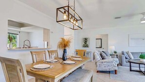 Un espace repas comprenant une table en bois, des chaises et un luminaire suspendu.