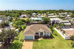 A residential area with houses, a swimming pool, and a boat dock. - Spacious, dog friendly home with pool, on waterway within minutes to the Gulf (Bokeelia)