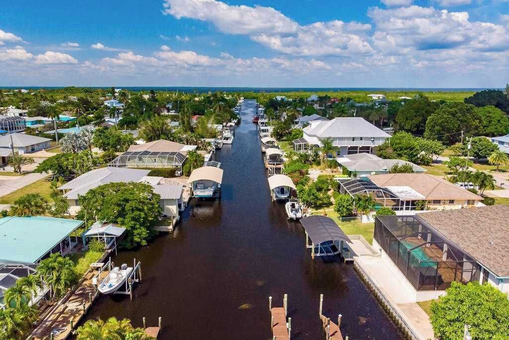 A canal lined with houses and boats, with a clear sky above.