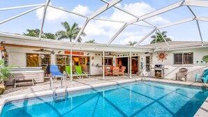 A swimming pool with lounge chairs, a covered patio, and a restaurant. - Canal-front home w/ private pool, hot tub, dock & kayaks/paddleboards -1 dog OK (Cape Coral)