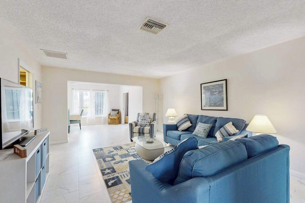 A modern living room with a blue sofa, a coffee table, and a TV on a stand.
