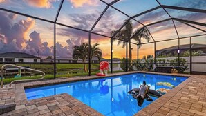 A swimming pool with a clear view of the sky and palm trees. - Dog-friendly (hypoallergenic), Heated pool, Game Room, Smart T.V.'s and More (Cape Coral)