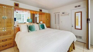 Une chambre avec un grand lit, une armoire en bois et une porte portant l’inscription « Voile ».