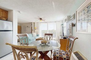 A dining area with a round table, chairs, and a ceiling fan. - Coastal studio with water views, shared pool, and internet (Bonita Springs)