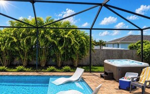 A backyard with a swimming pool, lounge chairs, a hot tub, and a wooden fence. - Heated Pool & Hot Tub | Relaxing Southwest Florida Escape (Cape Coral)