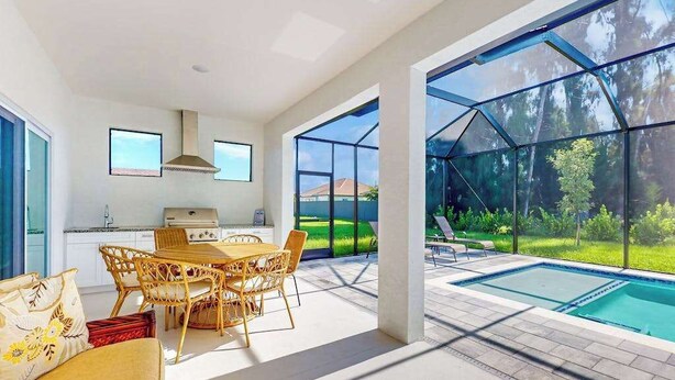 Una cocina moderna con comedor, piscina y vistas al exterior.
