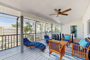 A covered outdoor patio with wooden furniture, a ceiling fan, and a view of the outdoors. - Tranquil home with washer/dryer, central AC, & kitchen - snowbird friendly (Englewood)