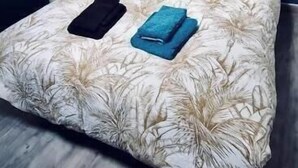 A bedroom with a bed, a nightstand, and a blue wall. - Cosy house with terrace near Rouen - Peace and comfort 10 min from the center (Amfreville-la-Mi-Voie)