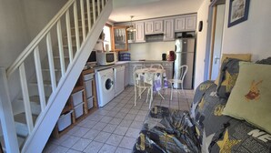 Een kleine keuken met een wasmachine, een magnetron en een koelkast.