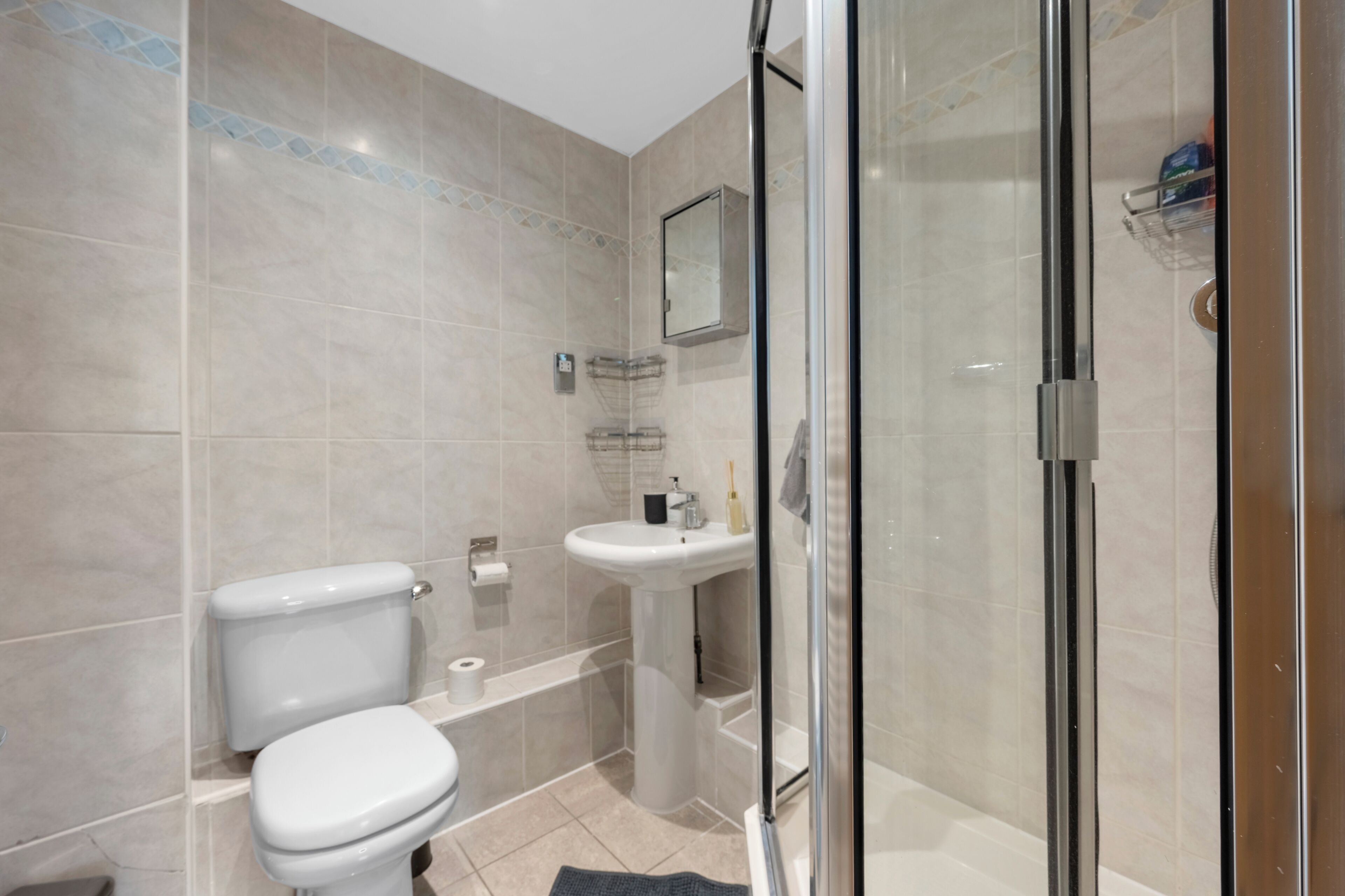 Une salle de bain comprenant des toilettes, un lavabo et un espace douche.