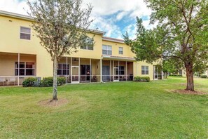 A two-story building with a flat roof, large windows, and a covered outdoor area. - Family-Friendly Townhouse with Shared Pool - Close to Golf & Beach (Fort Myers)