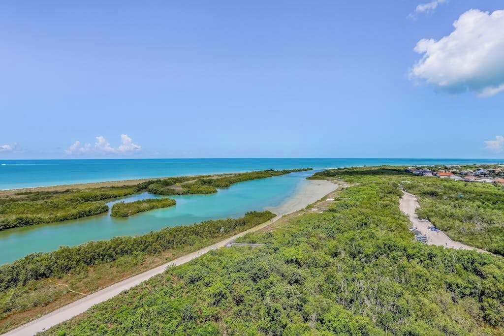 A coastal landscape with a clear sky, a road, and a beach area.