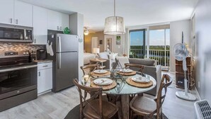 Eine moderne Küche mit Essbereich, großen Fenstern und einem Balkon.