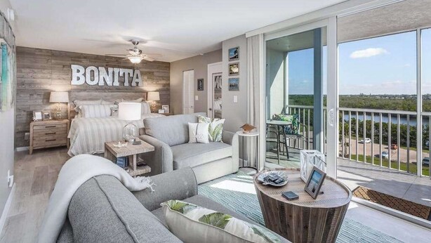 Ein modernes Wohnzimmer mit Balkon, einem Bett, einer Couch und einem Couchtisch.