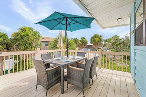 A wooden deck with a table and chairs, an umbrella, and a view of the surrounding area. - Blissful Beach Retreat A, Close to Beaches, Dog-Friendly, Private Deck (Englewood)