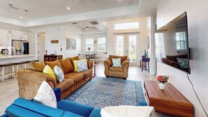 A spacious living area with a sofa, armchair, and coffee table. - Dog-friendly Waterfront home with private pool, on-site fishing (Cape Coral)