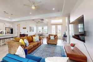 A spacious living area with a sofa, armchair, and coffee table. - Dog-friendly Waterfront home with private pool, on-site fishing (Cape Coral)