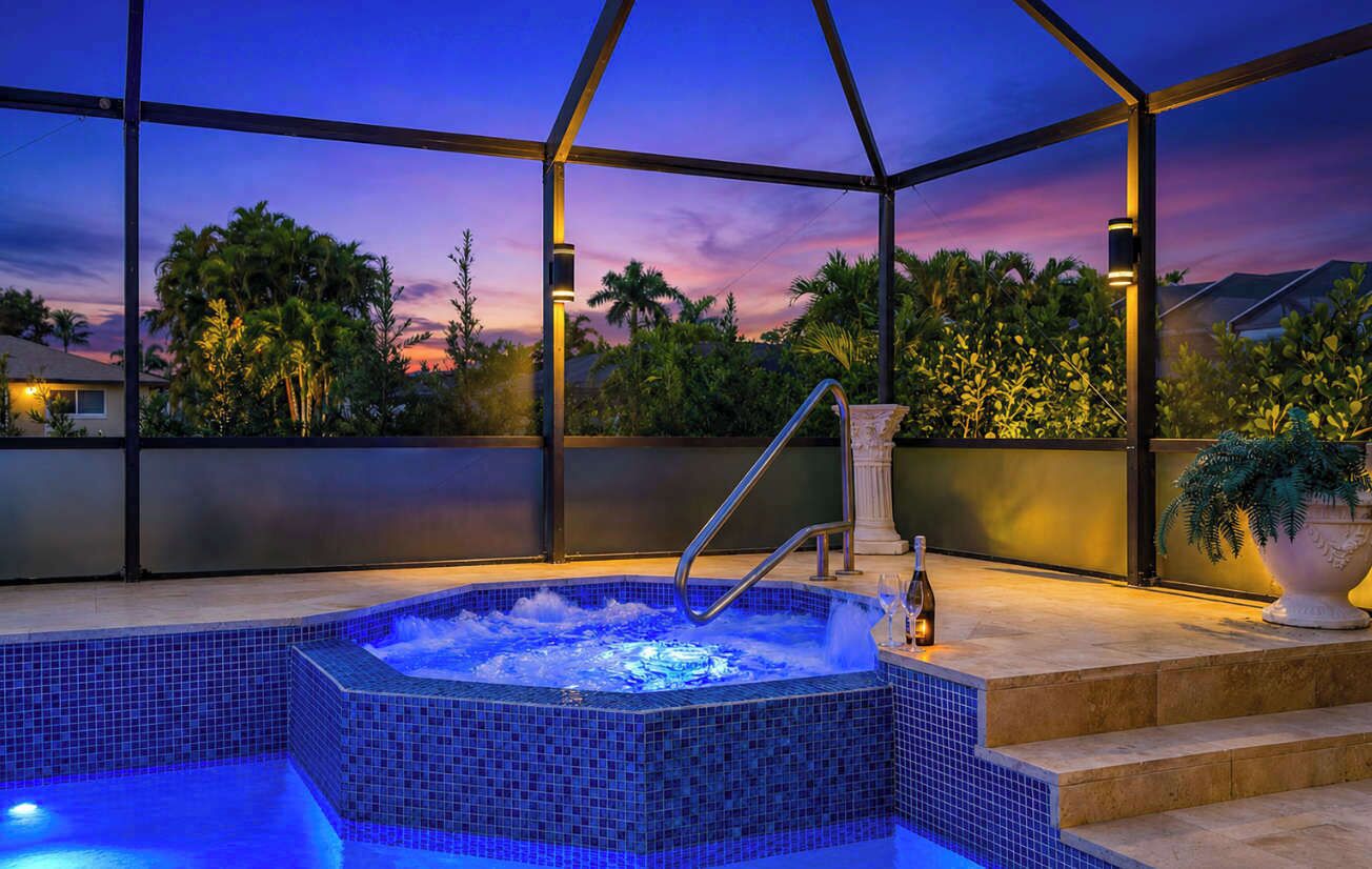 A hot tub with a view of palm trees and a sunset.