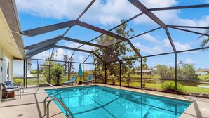 A covered outdoor swimming pool with a view of the surrounding landscape. - Dog friendly house with private pool, lanai, and washer & dryer (Rotonda West)