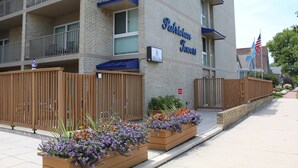 Monikerroksinen rakennus, jossa on parvekkeita, kyltti, jossa lukee ”Patriquin Towers”, ja lippu.