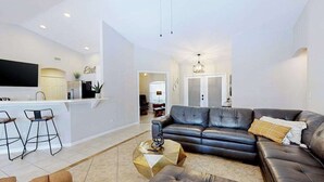 Ett modernt vardagsrum med en soffa, ett soffbord och barstolar.