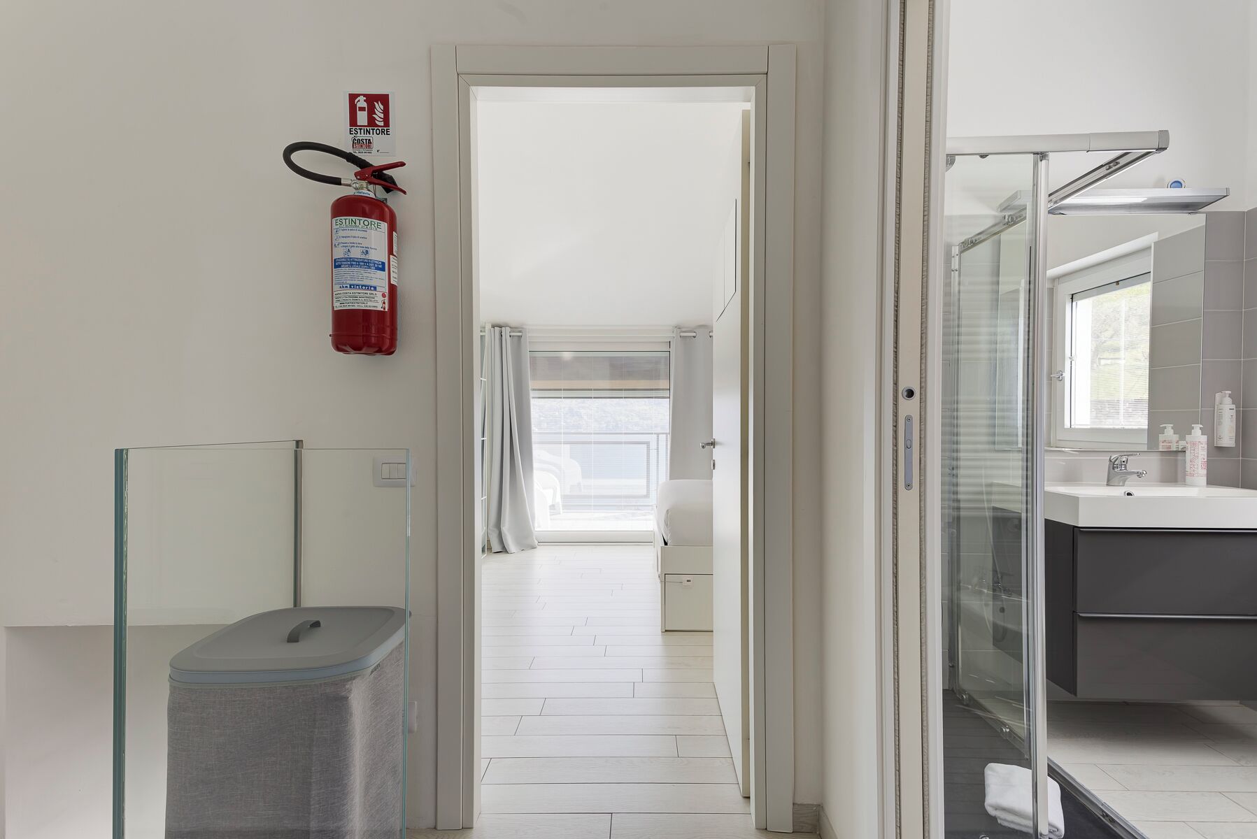 A modern bathroom with a glass shower enclosure, a sink, and a mirror.