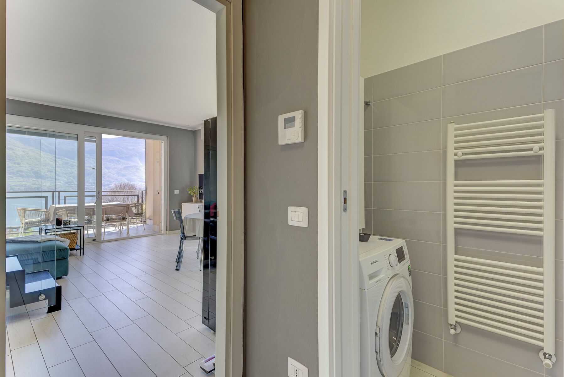 Un apartamento moderno con balcón, lavadora y vistas al exterior.