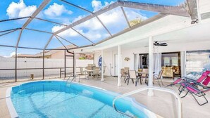Piscina interior com teto de vidro, cadeiras de descanso e área de terraço.