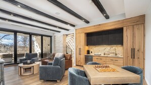 Ein modernes Wohnzimmer mit einem Holztisch, grauen Sofas und einem Schachbrett.
