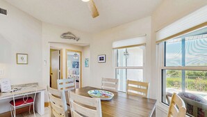 Un coin repas avec une table en bois, six chaises et un bol décoratif.