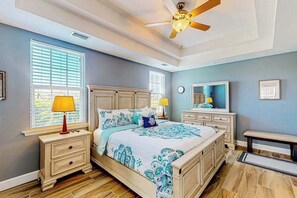 A bedroom with a bed, nightstands, a bench, a ceiling fan, and a window with blinds. - Water-view condo with screened patio, pool, central AC, & private washer/dryer (Fort Myers)