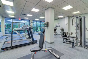 Ein Fitnessstudio mit Laufbändern, Kraftgeräten und Trainingsbänken.