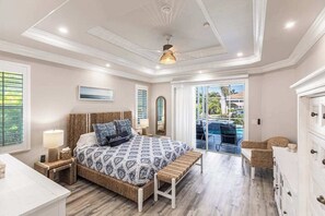 A bedroom with a bed, bedside table, lamp, and a view of the outside. - Elegant and luxurious waterfront home with heated pool, dog friendly, WIFI (Marco Island)