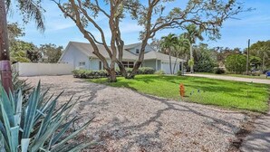 A house with a front yard, a driveway, and a fire hydrant. - Charming getaway in prime location with fast WiFi, W/D, and central AC (Bonita Springs)