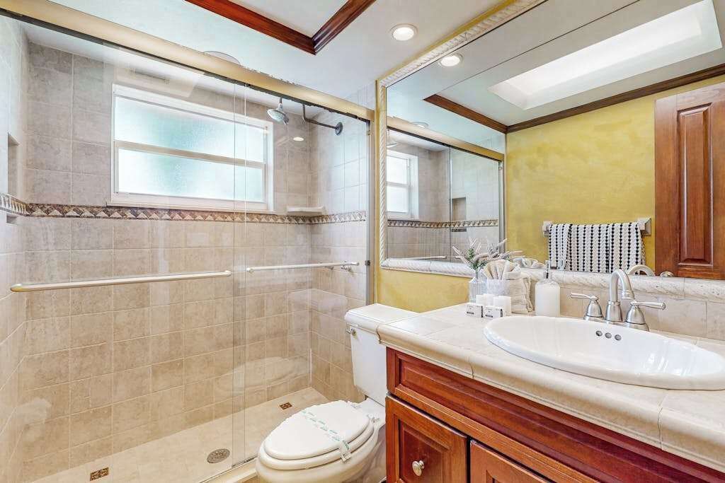 Une salle de bain équipée d’une douche, de toilettes, d’un lavabo et d’un meuble-lavabo.