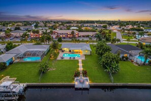 A residential area with houses, a swimming pool, and a dock. - Open-Air Waterfront Retreat | Private Pool (Cape Coral)