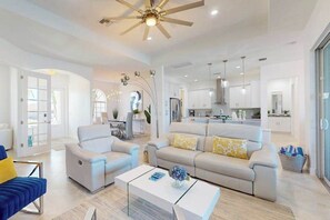 Un salon moderne avec un canapé, une table basse et un ventilateur de plafond.